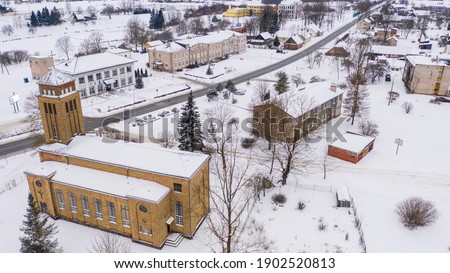 Akniste, Jekabpils, Latvia, Baltics. Beautiful panoramic aerial view photo from flying drone to Akniste Catholic Church In white snow on a snowy winter day. Architectural Heritage. (series)