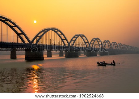 The Godavari Arch Bridge is a bowstring-girder bridge that spans the Godavari River in Rajahmundry, India. It is the latest of the three bridges that span the Godavari river at Rajahmundry. Royalty-Free Stock Photo #1902524668