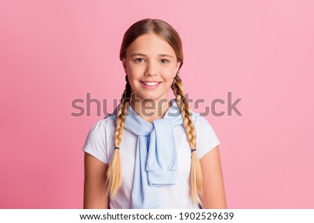 Photo portrait little schoolgirl wearing braids white t-shirt smiling isolated on pastel pink color background