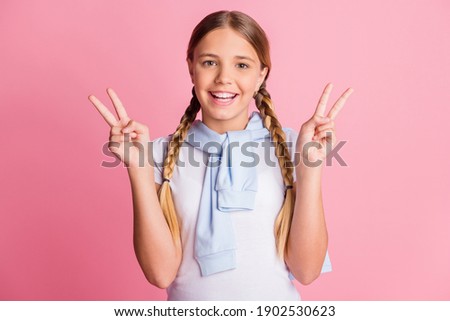 Photo of young preteen girl happy smile show peace cool v-sign jumper on shoulders isolated over pink color background