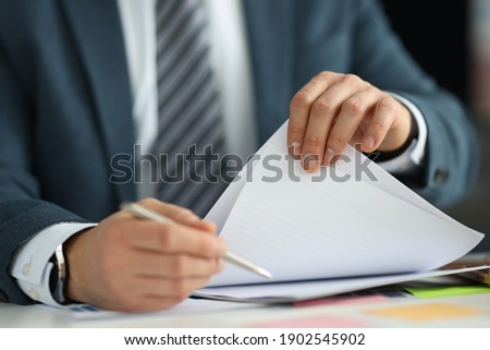 Businessman in suit holding documents in his hands in office closeup. HR management concept Royalty-Free Stock Photo #1902545902