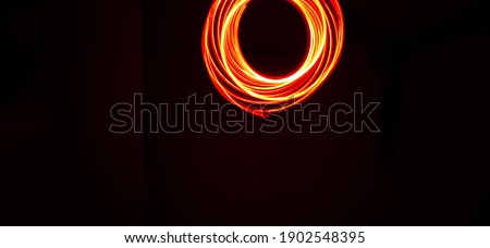 Abstract of pendulum pattern rings made in a Black background with glowing neon red using Light painting technique