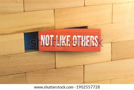 Not like others new trendy business concept image maded with wooden pegs, red wooden blocks, photo