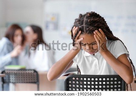 Pupils bullying African-American girl at school. Stop racism Royalty-Free Stock Photo #1902560503