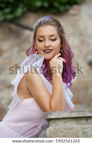 Portrait of a bride with purple hair close-up. A woman in a beautiful dress is resting