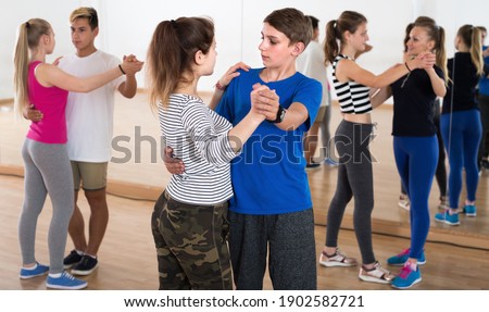 Portrait of teenagers dancing of partner dance at dance school Royalty-Free Stock Photo #1902582721