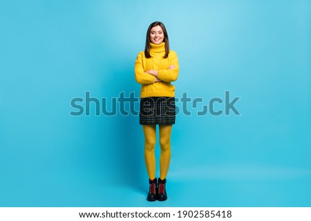 Full length photo of charming confident young lady wear yellow sweater arms crossed isolated blue color background