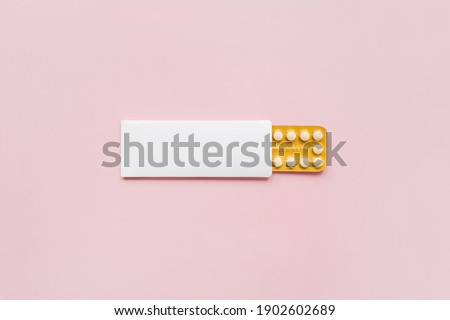 Hormonal oral contraceptives pills in a blister for a month of reception lie on pastel pink background. Flat lay, top view, copy space. Royalty-Free Stock Photo #1902602689
