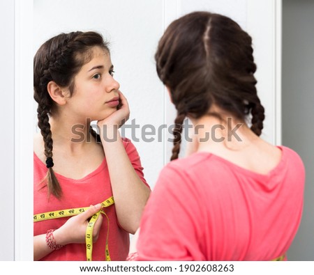 Young girl feeling unhappy with breast size gain at home Royalty-Free Stock Photo #1902608263