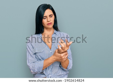 Young caucasian woman wearing casual clothes suffering pain on hands and fingers, arthritis inflammation  Royalty-Free Stock Photo #1902614824
