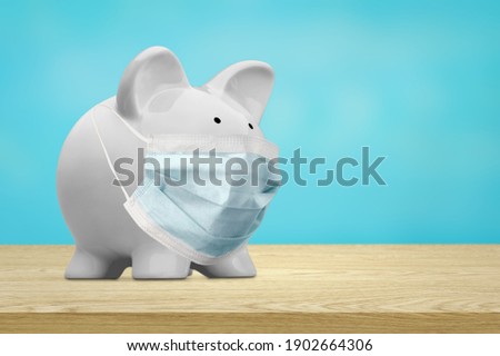 Cute piggy bank, wearing a protective face mask Royalty-Free Stock Photo #1902664306