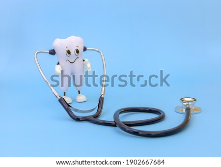 cartoon model of a tooth with a stethoscope on a blue background. Monitoring the health of the oral cavity