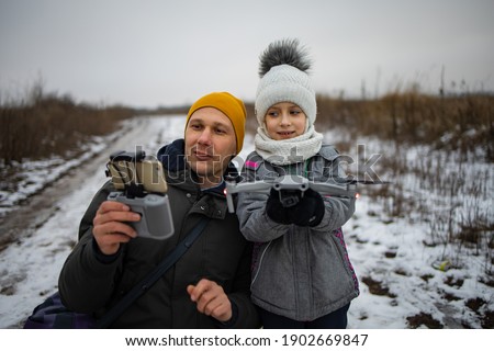 Father And Daughter Spending Time Together. Father And Son Set Up Drone In Winter Outdoor.