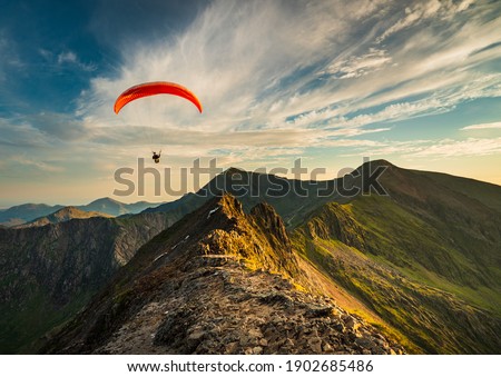 Paraglider flying along Crib Goch Royalty-Free Stock Photo #1902685486