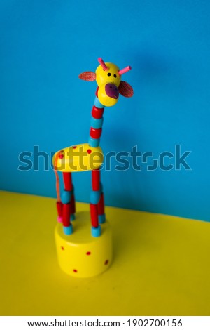 Wooden Giraffe toy with Blue and Yellow background