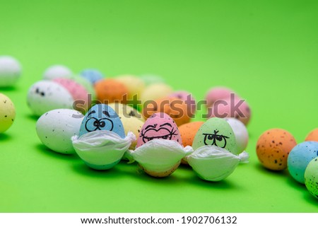 Funny three eggs in a mask for Easter on a green background