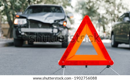 Red emergency stop triangle sign on road in car accident scene. Broken SUV car on road at traffic accident. Car crash traffic accident on city road after collision. Long web banner Royalty-Free Stock Photo #1902756088