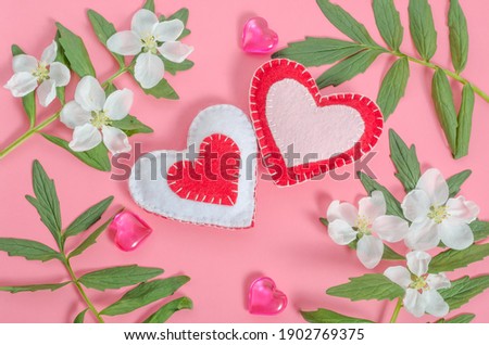 Valentine's day card, two hearts with a frame of flowers on a pink background