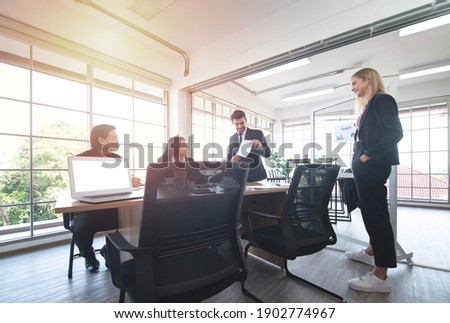 Caucasian Asian business man giving a presentation to associates in meeting room. Royalty-Free Stock Photo #1902774967