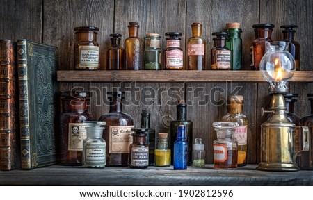 Bottles with drugs from old medical, chemical and pharmaceutical glass. Chemistry and pharmacy history concept background. Retro style. Chemical substances. Royalty-Free Stock Photo #1902812596