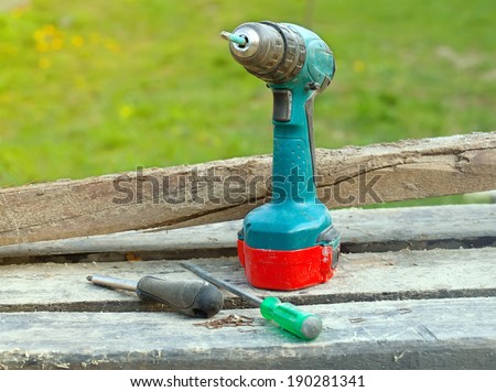 different screwdrivers on wooden table on green background