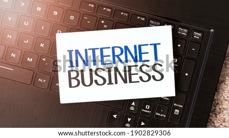 White paper sheet with text internet business on the black laptop