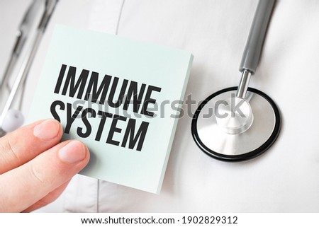 Doctor holding card in hands and pointing the word immune system