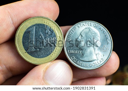 Quarter dollar and one euro close up photo. Macro coins.