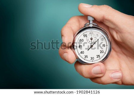 Silver classic stopwatch in human hand Royalty-Free Stock Photo #1902841126