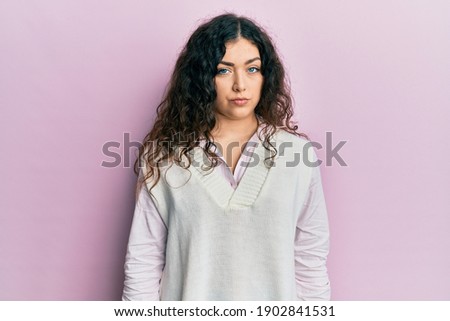 Young brunette woman with curly hair wearing casual clothes looking sleepy and tired, exhausted for fatigue and hangover, lazy eyes in the morning. 