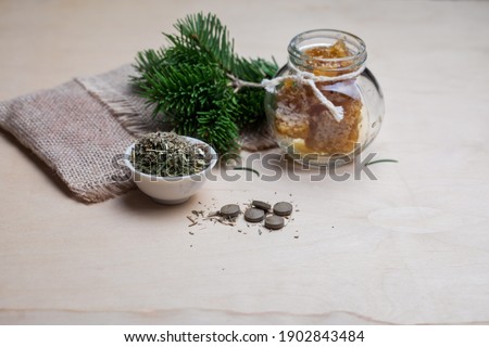 Tablets from natural ingredients, phyto pharmacy. A jar of honey, a bouquet of pine branches and herbal tea. Elements of traditional medicine. Royalty-Free Stock Photo #1902843484