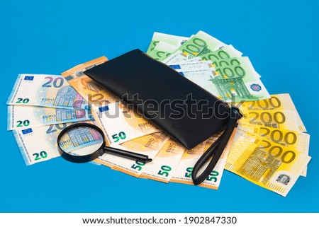 20, 50, 100, 200 euro bills and magnifying glass with black wallet. Concept of counterfeit money. The concept of cash, cash savings, prosperity. Euromoney