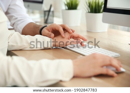 Man flirting with his colleague during work in office, closeup Royalty-Free Stock Photo #1902847783