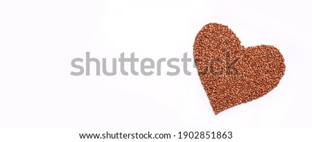 Buckwheat groats are laid out with a heart on a white background. Happy Valentine's Day. Valentine's Day background.