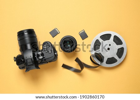 Flat lay composition with camera and video production equipment on yellow background