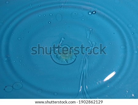 a dirty drop of water falls on the surface of the liquid