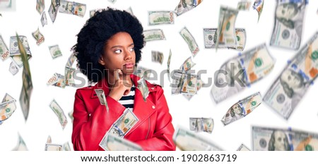 Young african american woman wearing red leather jacket serious face thinking about question with hand on chin, thoughtful about confusing idea