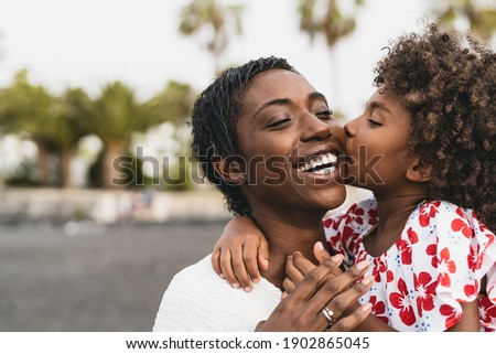 Happy African family on the beach during summer holidays - Afro American people having fun on vacation time - Parents love unity and travel lifestyle concept