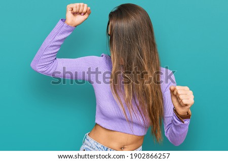Young hispanic woman wearing casual clothes dancing happy and cheerful, smiling moving casual and confident listening to music 