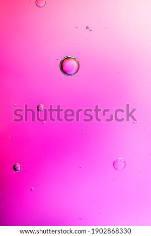 oil drops on a water surface abstract background with pink colors