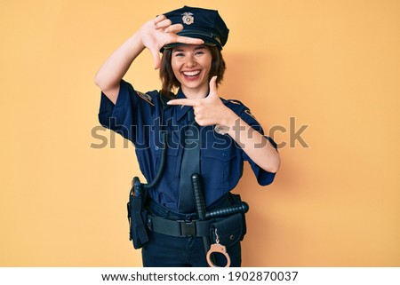 Young beautiful woman wearing police uniform smiling making frame with hands and fingers with happy face. creativity and photography concept. 