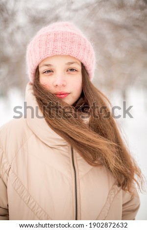 A winter portrait of a girl  smiling. Image with selective focus and toning