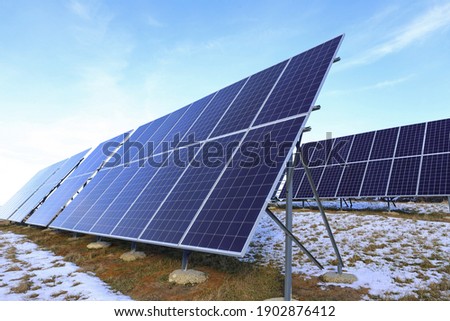 Solar panels Photovoltaic cells on a background of sunrise. Solar panels, the beginning of winter. Alternative ecological energy. Royalty-Free Stock Photo #1902876412