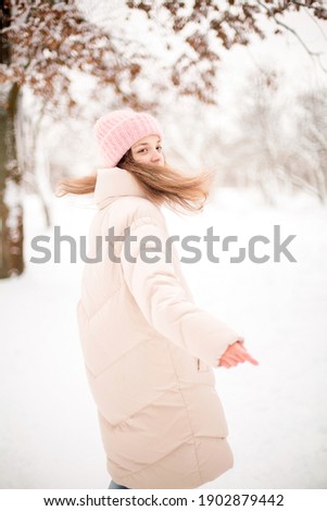 
Girl running and playing in the park on a snowy day
