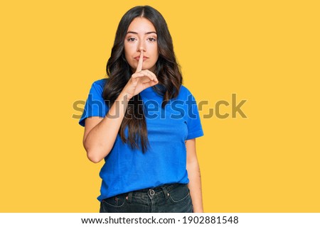 Beautiful brunette young woman wearing casual clothes asking to be quiet with finger on lips. silence and secret concept. 