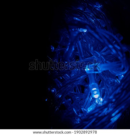Blue bulbs. Christmas lights on dark blue background with copy space. Decorative garland