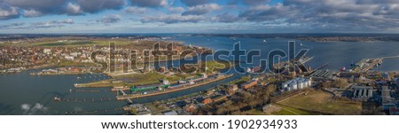 Panorama aerial view of the Kiel Canal waterway with lockage Holtenau. Cargo ships pass the Holtenau lock of the Kiel Canal. Industrial area at the Kiel Canal. Royalty-Free Stock Photo #1902934933