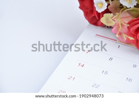 White desk calendar of February with rose flower, concept for valentines day on 14th February 2021. Selective and soft focus
