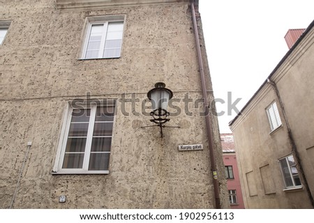 Translation from Lithuanian: Shoe street. A part of sanstone house facade with window and an ancient lantern. Street view cityscape of Klaipeda city, Litrhuania.