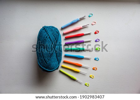 Flat lay of knitting string and hooks over a clear background